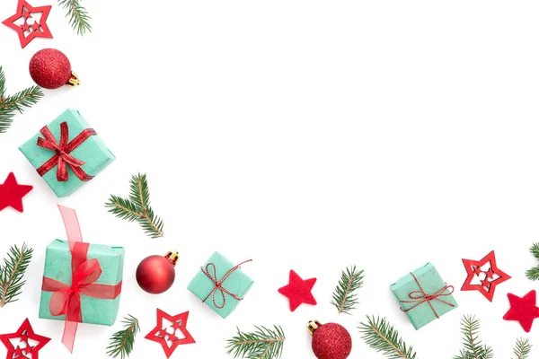 Noel süsler (küçük Noel hediyeleri, kırmızı Noel topları, yeşil Çamın dalları ve kırmızı yıldız) beyaz arka plan ile kış çerçeve.