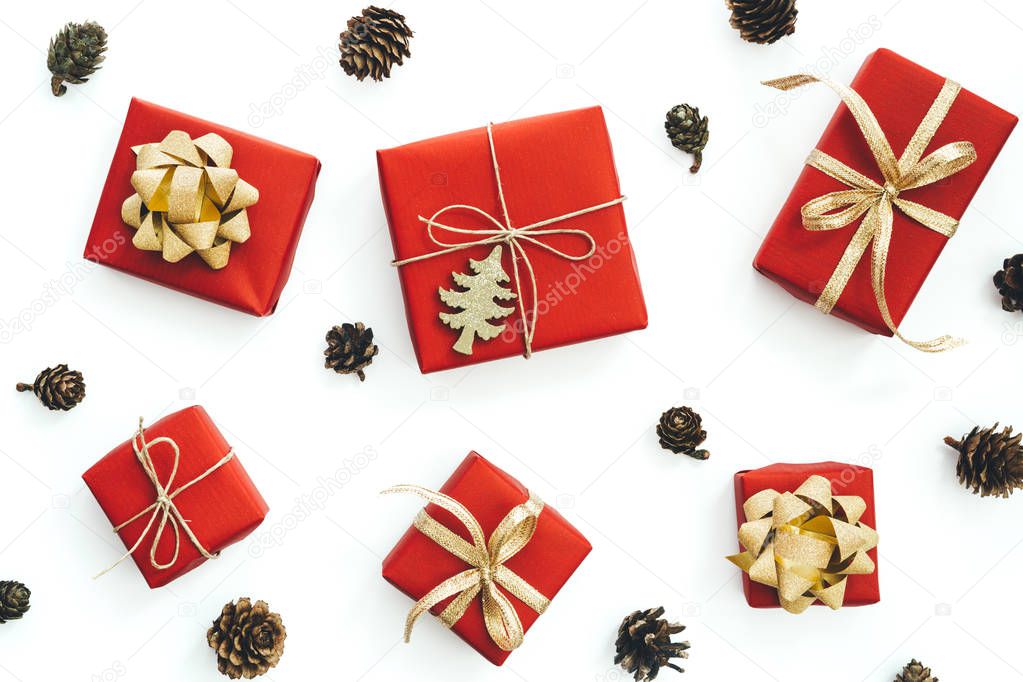 Christmas arrangement with small presents wrapped in red paper with gold ribbons on white background.