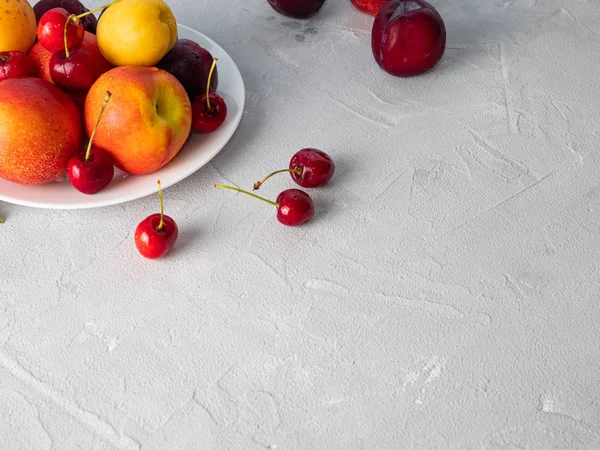 Beau fruit mûr sur une assiette blanche . — Photo