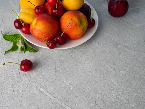 Beau fruit mûr sur une assiette blanche . — Photo