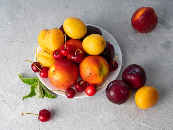 Beau fruit mûr sur une assiette blanche . — Photo