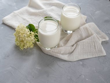Gri bir arka plan üzerinde iki bardak doğal süt. Kopyalama alanı.
