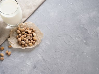 Bir cam Bardak antep fıstığı süt ve gri beton arka plan üzerinde antep fıstığı. Kopyalama alanı.