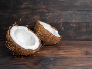 Koyu ahşap bir arka plan üzerinde taze hindistan cevizi iki yarısı. Kopya sp