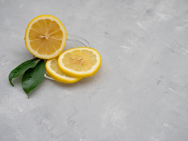 Lemon cut with lemon slices on a transparent plate, decorated wi