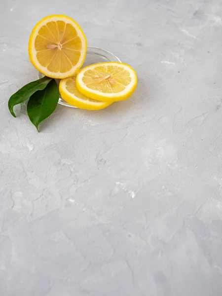 Lemon cut with lemon slices on a transparent plate, decorated wi