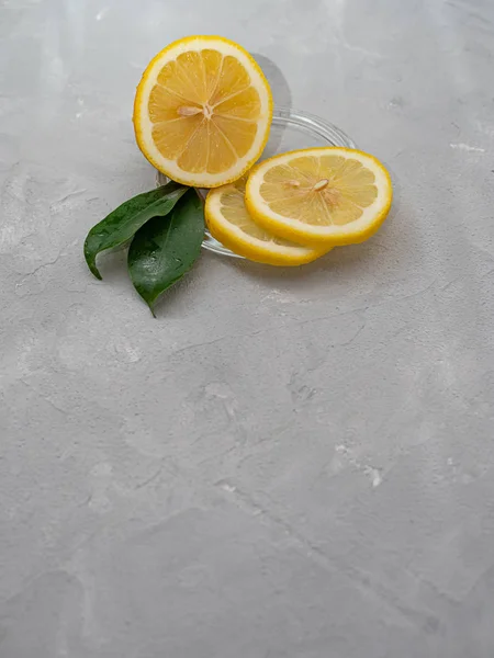 Lemon cut with lemon slices on a transparent plate, decorated wi