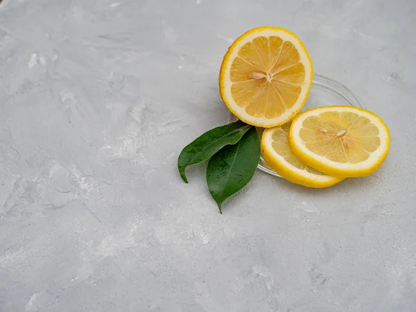 Lemon cut with lemon slices on a transparent plate, decorated wi