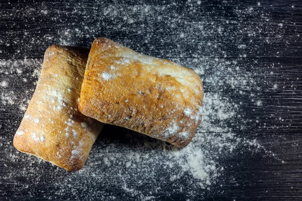 黑木背景上的两条面包 Ciabatta — 图库照片