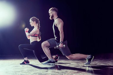 Yakışıklı sporcu ve birlikte siyah üzerine eğitim genç uygun kadın yan görünüm