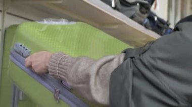 Süpermarketten bir bavul seçiyor.