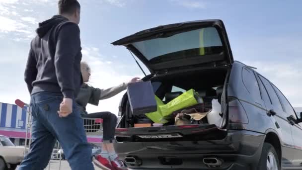 Gehuwd stel laadt aankopen in een auto — Stockvideo