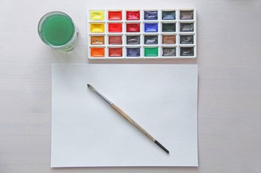 Suluboya, fırçalar, beyaz kağıdın ve bir bardak su çizim için. Hobiler ve yaratıcılık.