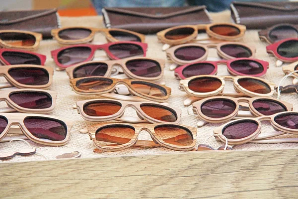 Sunglasses in a wooden frame. Many sunglasses. Designer glasses.