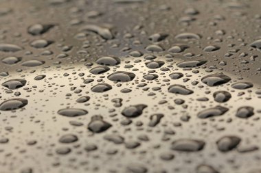 Yağmur veya su damla arabanın kaputu bırakın. Arabanın yüzeyinde veya demir yüzey akışı üzerinde yağmur düşer. Arka plan ve su doku tasarımı için.