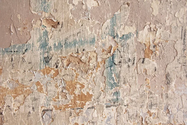 汚れたひび割れた壁を剥がす古いフレーク状の白い塗料。亀裂, — ストック写真