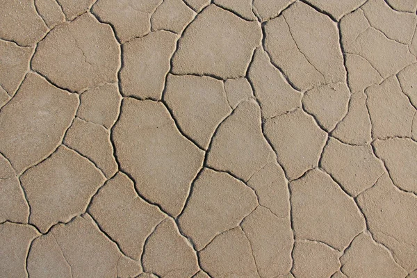 Torr sprucken jord bakgrund. Knäckt lera mönster. Jord i spricka — Stockfoto