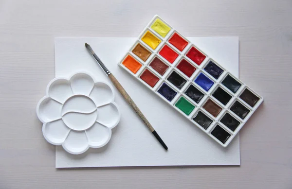 Akvarelleket, ecsetek, paletta, fehér papírlap, rajz. — Stock Fotó