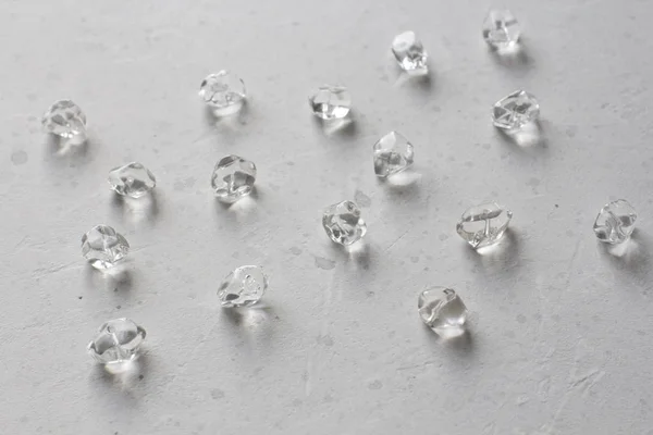 돌 모조 다이아몬드입니다. 회색 모더 위에 자연스러운 투명 돌이 놓여 있습니다. — 스톡 사진