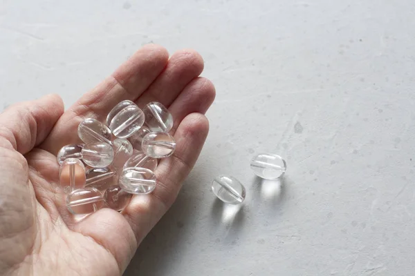 Piedra de imitación se encuentra en la mano de una mujer. Natural transparente sto —  Fotos de Stock