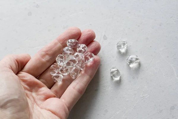 Pedra strass está na mão de uma mulher. Transparente natural — Fotografia de Stock