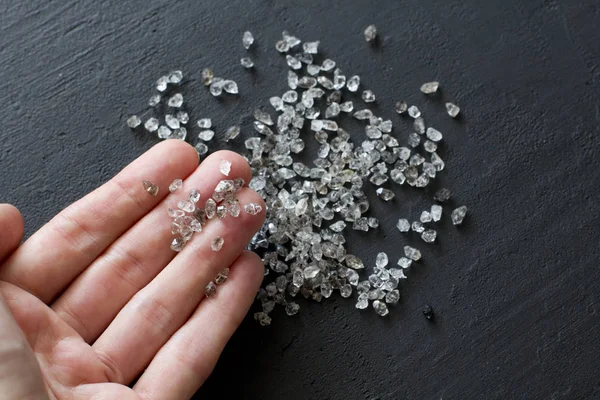 Diamantes naturales crudos, cuarzo de grafito están en la mano. Una dispersión —  Fotos de Stock