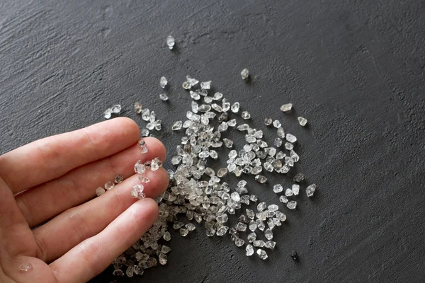 Diamantes naturales crudos, cuarzo de grafito están en la mano. Una dispersión —  Fotos de Stock