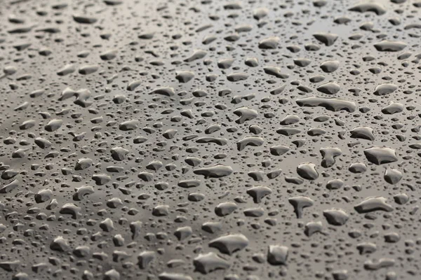 Gocce di pioggia o goccia d'acqua sul cofano dell'auto. Gocce di pioggia o — Foto Stock