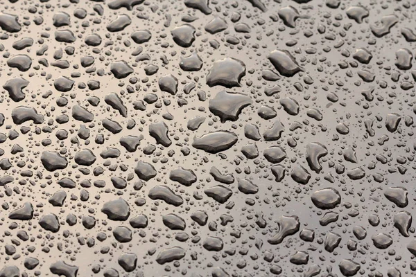 Regentropfen oder Wassertropfen fallen auf die Motorhaube des Autos. Regentropfen — Stockfoto