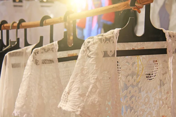 Weiße Baumwollhemden mit Stickereien hängen an Kleiderbügeln und werden verkauft — Stockfoto