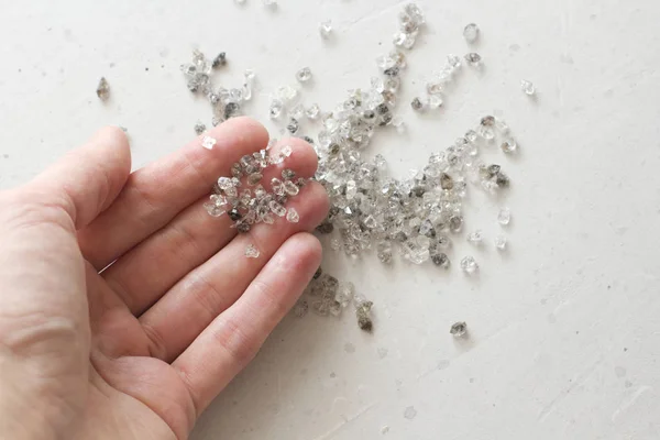 Raw natural diamonds, graphite quartz are in the hand. A scatter — Stock Photo, Image