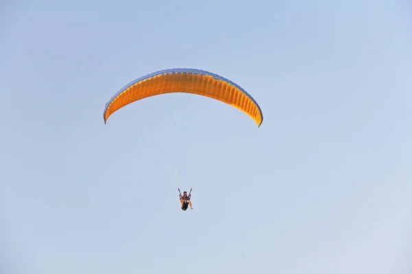 A paraglider against the blue sky. A bright paraglider flies in — Stock Photo, Image