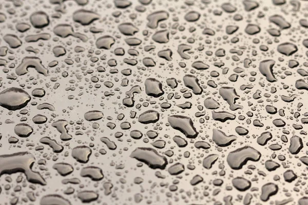 Regentropfen oder Wassertropfen fallen auf die Motorhaube des Autos. Regentropfen — Stockfoto