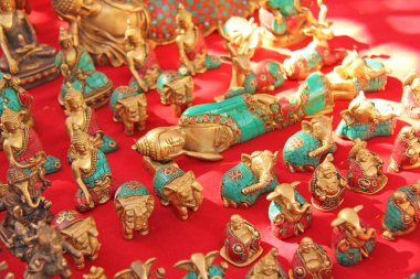 Kırmızı bir arka plan ve diğer bronzdan yapılmış bir uzanmış Buda 