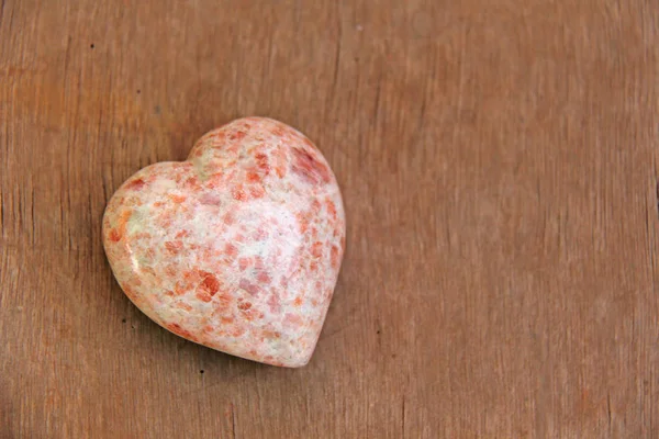 Coração rosa feito de pedra natural rhodochrosite. Um coração em forma s — Fotografia de Stock
