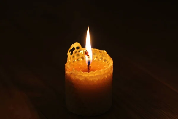 Candle, one candle flame at night closeup on a black background.