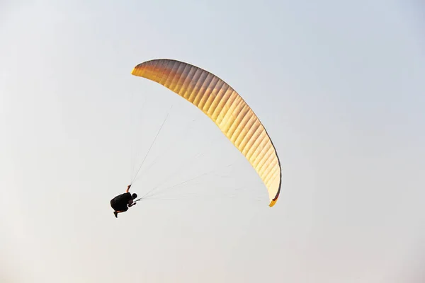 A paraglider against the blue sky. A bright paraglider flies in — Stock Photo, Image