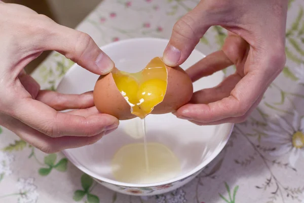 Two yolks in one egg. 2 in 1. Women's hands open a unique egg wi — Stock Photo, Image