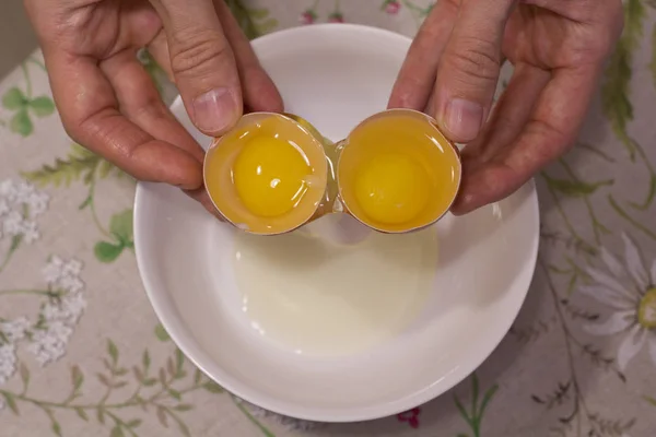 Two yolks in one egg. 2 in 1. Women's hands open a unique egg wi — Stock Photo, Image