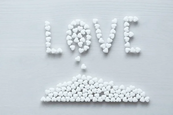 Ordet kärlek är fodrad eller skriven från vita hjärtan på en vit b — Stockfoto