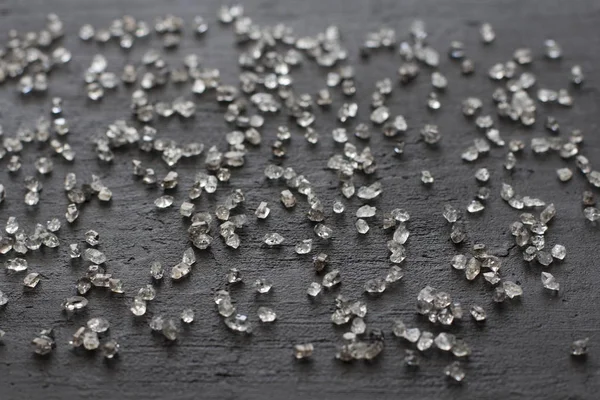 Scattered diamonds on a black background. Raw diamonds and minin