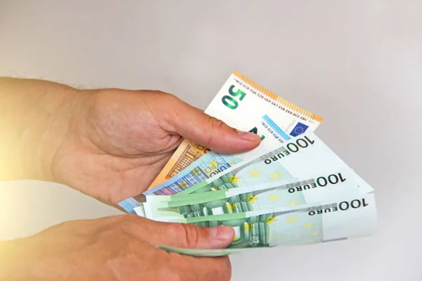 A mão do homem segura os 100 euros, considera-os e paga. Pape. — Fotografia de Stock