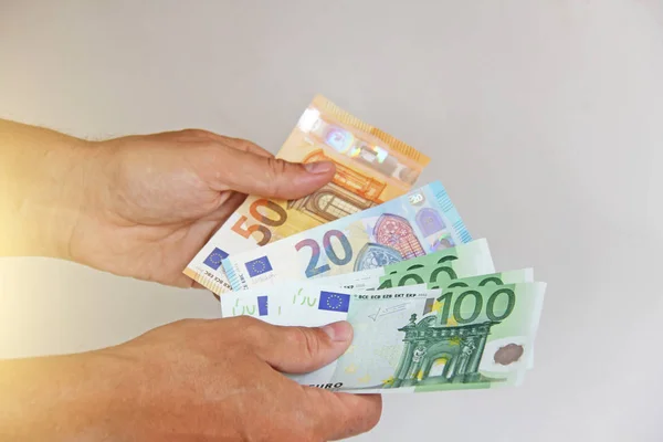男人的手拿着100欧元，考虑他们，并支付。佩普 — 图库照片