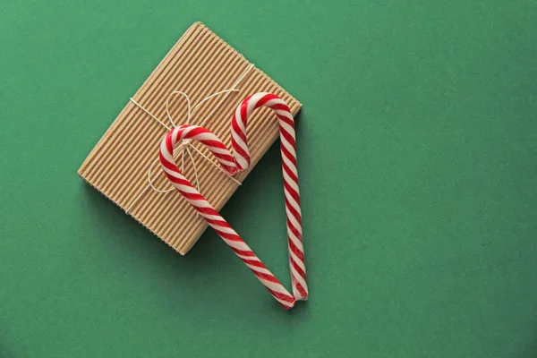Scatola di colore marrone Kraft regalo e bastoncini di zucchero rosso e bianco in ascolto — Foto Stock