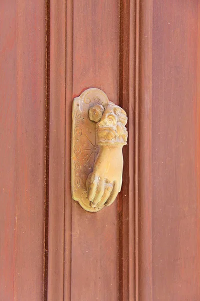 Ancient door handle in the form of a hand made of yellow metal a