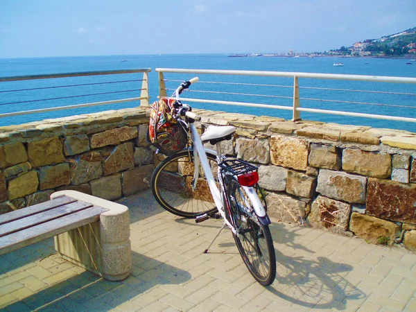 White bicycle with a basket on the background of the blue sea