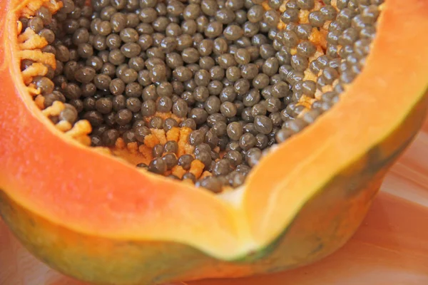 Orange open papaya with black seeds. Papaya close-up. Fruits of — Stock Photo, Image