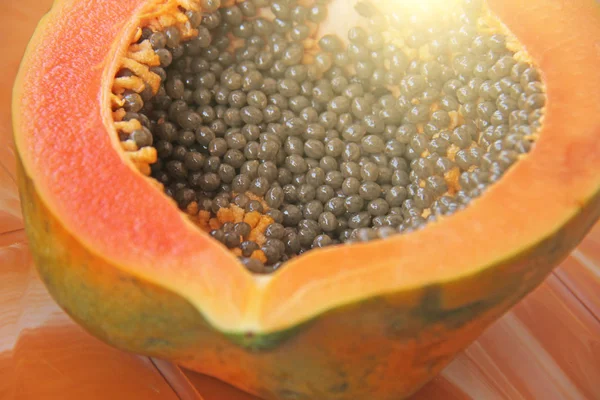 Orange open papaya with black seeds. Papaya close-up. Fruits of