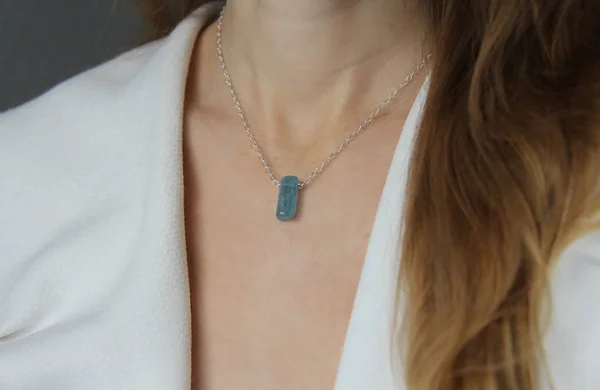 Kristallblauer Aquamarin-Beryll an einer silbernen Kette am Mädchen. Stift — Stockfoto