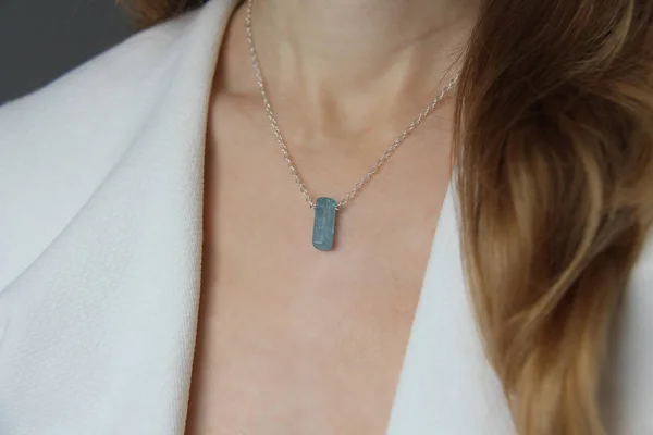 Kristallblauer Aquamarin-Beryll an einer silbernen Kette am Mädchen. Stift — Stockfoto